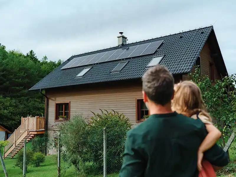 Father and daughter looking at solar panels on their home
